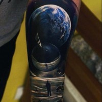Tatuaje en el antebrazo, hombre en Marte y dos planetas grandes