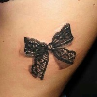 carino fiocco nero di pizzo tatuaggio su coscia femminile