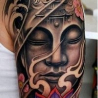 bella faccia buddista con loto tatuaggio su braccio