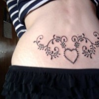 Lovely heart with patterns tattoo on lower back