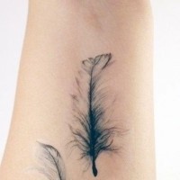 Tatuaje  de plumas sutiles en el antebrazo