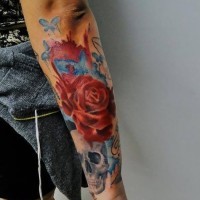 Tatuaje en el antebrazo, cráneo de acuarelas con rosa y mariposas