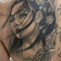Magisch aussehendes farbiges schönes Porträt  der asiatischen Frau Tattoo an der Schulter mit blühenden Blumen