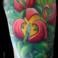 Magical looking colored shoulder tattoo of beautiful flowers with leaves
