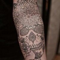 Tatuaje en el antebrazo, calavera de azúcar con flores, dibujo no pintado