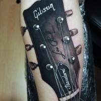 Tatuaje en el antebrazo, parte de guitarra Gibson excelente