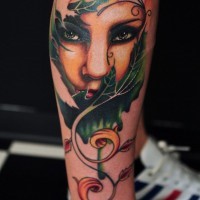 Magnificent colored mystical woman portrait tattoo on leg combined with leaves