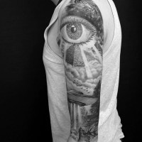Tatuaje en el brazo, ojo masónico grande con pirámide y nave extraterrestre