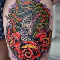 Herrlich aussehendes farbiges modernes Porträt der Meduse Tattoo am Oberschenkel mit Oldschool Blumen Rose