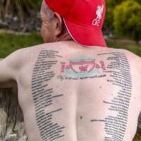 Magnificent looking colored whole back tattoo of Liverpool FC anthem