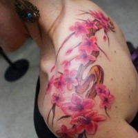 Magnificent pink flowers on branch tattoo on lady's shoulder