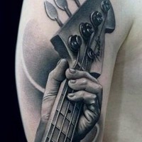 Tatuaje en el brazo, mano de músico que  toca la guitarra