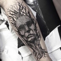 Man's portrait designed with tree elements forearm tattoo in surrealism engraving style