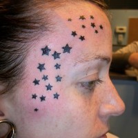 Tatuaje en la cara, un montón de estrellas negras