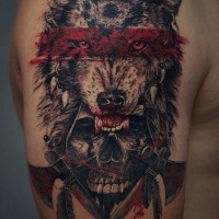 Tatuaje en el brazo,
cráneo humano con casco de lobo y dos hachas