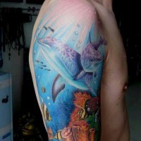Tatuaje en el brazo, delfines hermosos en el mundo subacuático pintoresco