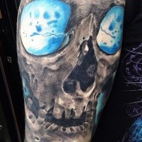 Marvelous multicolored shoulder tattoo of skull with blue eyes