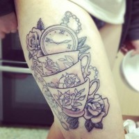 Tatuaje en el muslo,  tres tazas con flores y reloj