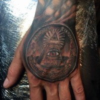Tatuaje en la mano,  moneda con pirámide masónica