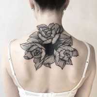 Tatuaje en la espalda alta, 
flores grandes visibles en colores negro blanco