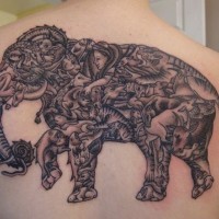 Massive colored elephant tattoo on upper back stylized with various animals