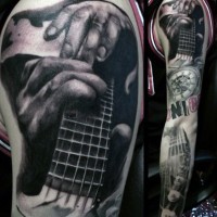 Tatuaje en el brazo,
tema musical negro blanco con guitarra  y manos