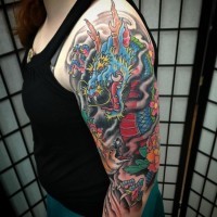 Tatuaje en el brazo,
dibujo multicolor fascinante de dragón que lucha con zorro