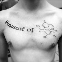 Meaningful dark black ink lettering Pursuit of tattoo on man's chest with chemical formula drawing