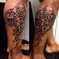 Medium size black ink slope tattoo on leg muscle stylized with tribal ornaments