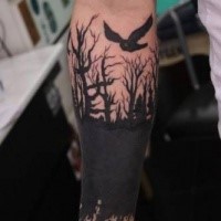 Mittlerer schwarzer im Arbeit Stil dunkler Wald mit Vogel Tattoo am Unterarm