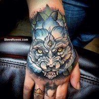 Medium size colored mystical wolf with three eyes tattoo on hand stylized with leaves