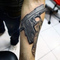 Medium size colored realism style modern pistol tattoo on forearm