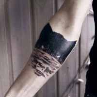 Mittelgroßes schwarzes Wolfskopf geformtes Tattoo am Unterarm mit Nachtwald