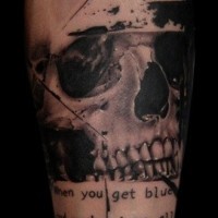Memorial like black and white little skull with lettering tattoo on arm