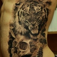 Menasing tiger with skull and feathers tattoo on ribs