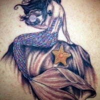 Tatuaje en la espalda,
sirena con perla y estrella de mar