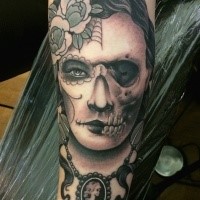 Mexican traditional colored forearm tattoo of half woman half skull portrait