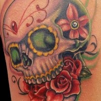 Mexican traditional colored human skull tattoo stylized with red flowers