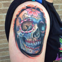 Mexican traditional style colored shoulder tattoo of human skull with flowers