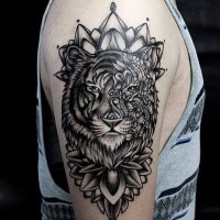 Modern style black ink shoulder tattoo of tiger stylized with various flowers