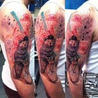Modern style colored shoulder tattoo of funny bear riding bicycle