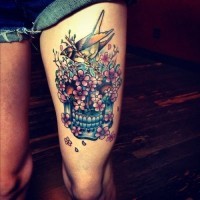Tatuaje en el muslo, calavera de azúcar con flores diminutas y pájaro