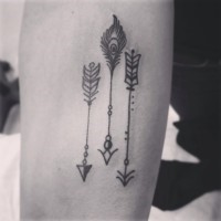 Tatuaje en el antebrazo,
flechas diferentes con plumas y perlas