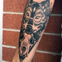Mysterious black ink forearm tattoo of animal skull with wolf head