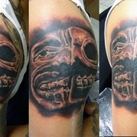 Mystisches farbiges Schulter Tattoo mit gruselig aussehendem Gesicht