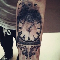 Mystical black pyramid tattoo on forearm with old clock and birds