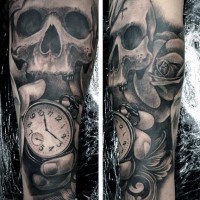Tatuaje en el antebrazo, cráneo con rosa y reloj en la mano