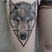 Mystical Engraving style wolf head tattoo on thigh stylized with human hear and black triangle