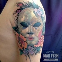 Mystical illustrative style colored shoulder tattoo of mystical mask with flowers