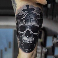 Mystical painted big black and white skull with cross tattoo on arm